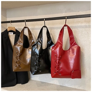 Three leather tote bags in brown, black, and burgundy with stylish eyelet lace-up details