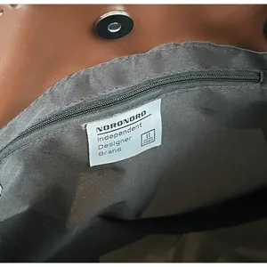 Dettaglio interno della borsa tote con chiusura magnetica ed etichetta del marchio