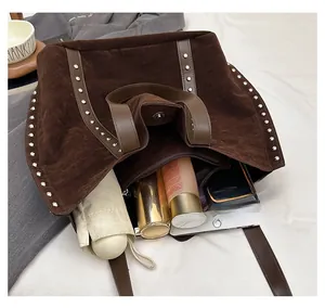 Internal view of a large brown suede tote bag showing its spacious capacity and rivets
