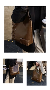Detail view of large dark brown tote bag with decorative lacing and side pouch