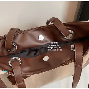 Dettaglio della chiusura magnetica di una grande borsa tote in pelle marrone