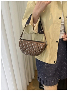 Brown rivet hobo bag on shoulder showing detailed metal studs and retro style