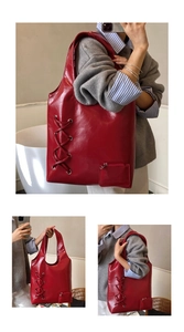 Macro shot of large red tote bag featuring metal eyelets and decorative side cross-lacing