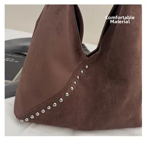 Detail showing comfortable frosted texture and silver studs on the dark brown tote bag