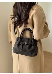 Close-up of vintage brown suede tote bag with golden buckle and sleek shoulder strap