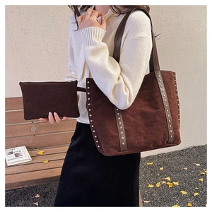 Detail of dark brown suede tote bag featuring silver studs and small inner pouch