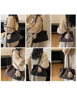 Detailed view of large slouchy tote bag with plush bear charm and long shoulder straps