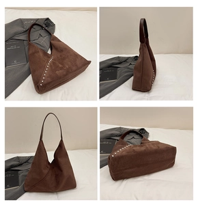 Close-up detail of dark brown suede tote with silver studs and premium leather strap