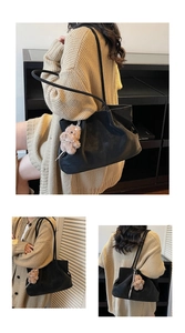 Detail of black leather tote bag with a brown plush bear charm and thin shoulder straps