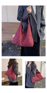 Detailed close-up of burgundy suede tote bag showing silver rivets and triangular panels