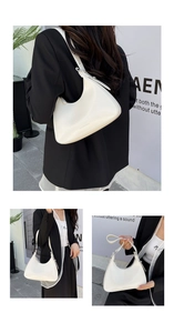 Detailed close-up of a white minimalist half-moon underarm bag in glossy leather