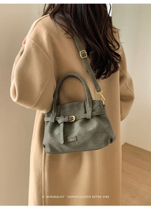 Detail of moss green pebbled leather bag with vintage gold hardware and Fashion tag