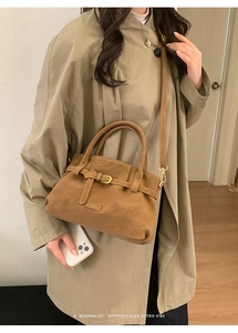 Detail of vintage brown suede tote showing metal buckle and fine stitching texture