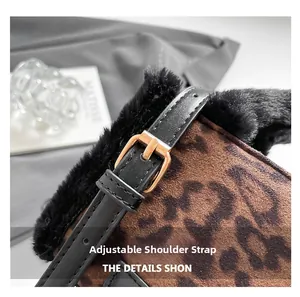 Détail de la bandoulière réglable en cuir noir avec boucle dorée sur sac léopard