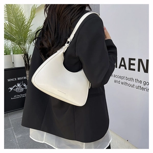 Detail of a minimalist white hobo bag showing the smooth matte finish and neat stitching
