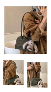 Close-up of vintage dark green suede tote bag with a cute white rabbit plush charm