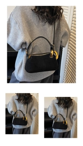 Detail of black suede Boston bag featuring chunky gold chain link and leather strap