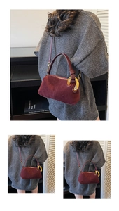 Close-up of burgundy suede Boston bag featuring vintage gold chain links and strap