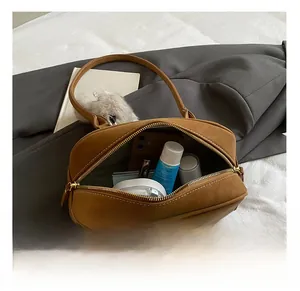 Detail of caramel suede tote interior showing spacious capacity for cosmetics and phone