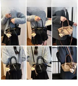 Detail view of suede tote bag with bear charm showing multiple carrying styles
