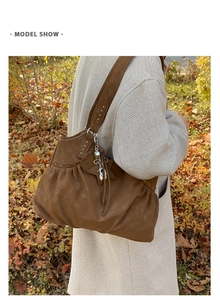 Brown suede tote bag with rivets and star tassel pendant detail on female model