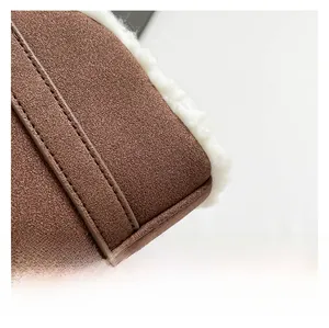 Macro shot of brown suede stitching with white faux shearling on a winter handbag