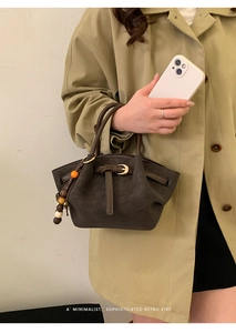 Détail macro du sac à main en daim plissé avec pendentif en perles et boucle métallique
