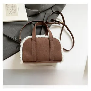 Detail of a brown suede crossbody bag with fleece trim and smartphone for size comparison