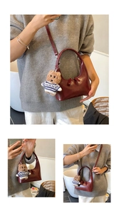 Détail du sac bandoulière croissant bordeaux avec une jolie breloque ours en peluche