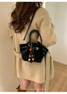 Détail du cabas en daim noir avec perles en bois colorées et boucle en métal rétro