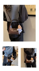 Vues détaillées d'un sac dumpling en cuir marron avec un charme d'ours mignon