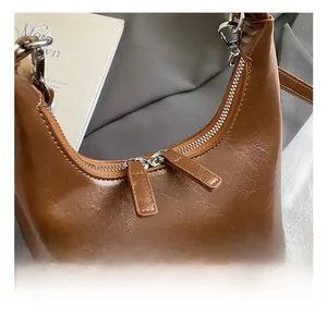 Détail du sac hobo en cuir brillant marron foncé vintage avec fermetures argentées