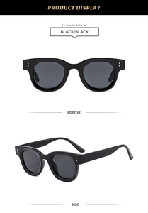 Détail de lunettes de soleil rondes vintage avec monture noire polie et rivets argentés