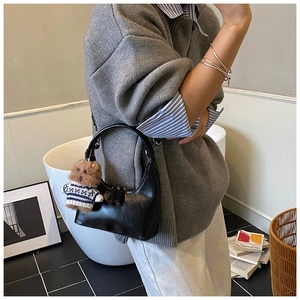 Détail du sac hobo noir en demi-lune avec un joli pendentif peluche ours brun
