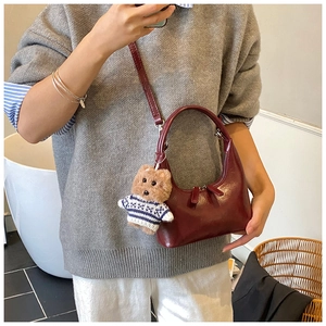 Détail du sac hobo bordeaux avec pendentif ours et bandoulière réglable pour femme