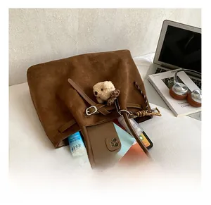 Macro detail showing spacious interior of brown suede tote bag with laptop and daily essentials
