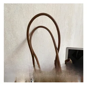 Detail of round leather handles and soft brown suede texture with a cute bear charm