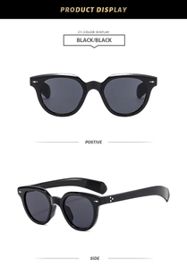 Detail of oval black sunglasses featuring silver star rivets and dark grey lenses