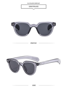 Detail view of oval trendy sunglasses with gray transparent frame and black lenses