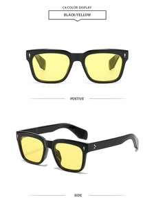Close-up of black square sunglasses with yellow lenses and silver arrow rivets