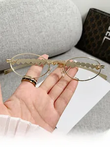 Close-up of golden oval sunglasses featuring heart-shaped metal trim and rhinestone bridge