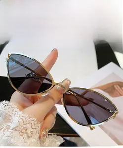 Gros plan de lunettes de soleil œil-de-chat dorées avec verres gris en style de vie