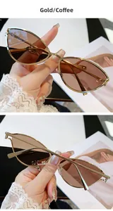 Détail de lunettes de soleil œil-de-chat dorées avec verres marron et monture fine