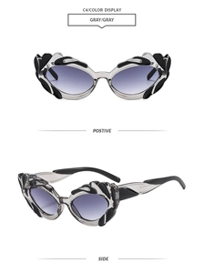 Detail view of cat eye sunglasses with grey gradient lenses and wave frame accents