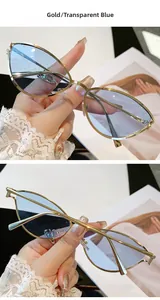 Détail de lunettes de soleil œil-de-chat dorées avec verres bleu clair transparents