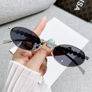 Oval silver metal sunglasses with rhinestone heart detail and black wavy floral temples