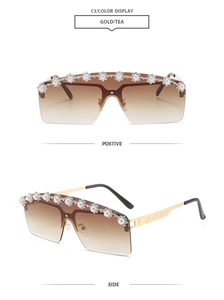 Close-up of rimless sunglasses with gold metal frame and pearl flower embellishments