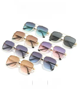 Detail of square pilot sunglasses featuring gold metal frames and gradient lens collection