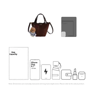 Detail view of brown suede bucket bag capacity with leather straps and bear charm