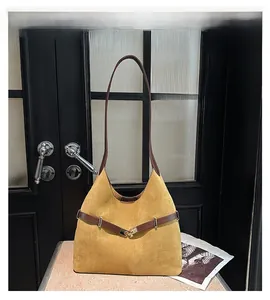Detail of vintage mustard suede tote with brown leather strap and golden metal buckle